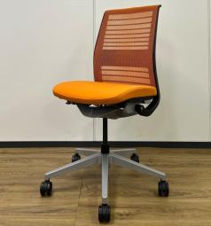 【定価約16万円】【ワイヤーが体にフィットするアメリカ発の大人気商品！長時間の着座ストレスを軽減！】 ■スチールケース（Steelcase）製　シンク（think）チェア　肘付き　ハイバック　■メッシュバック　■ランバー付　■背面：オレンジ/座面：ブラック